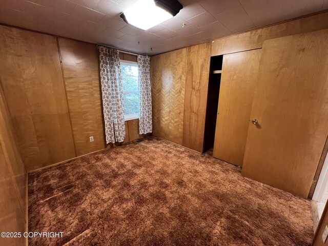 7700 Dover Ave, Anchorage, AK 99504 - empty room featuring carpet floors and wooden walls