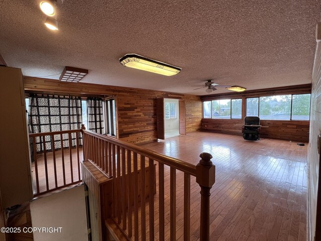 7700 Dover Ave, Anchorage, AK 99504 - corridor with wood walls, a textured ceiling, and hardwood / wood-style flooring