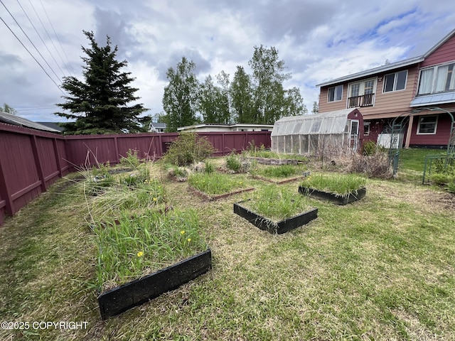 7700 Dover Ave, Anchorage, AK 99504 - view of yard featuring a vegetable garden, a greenhouse, and an outbuilding