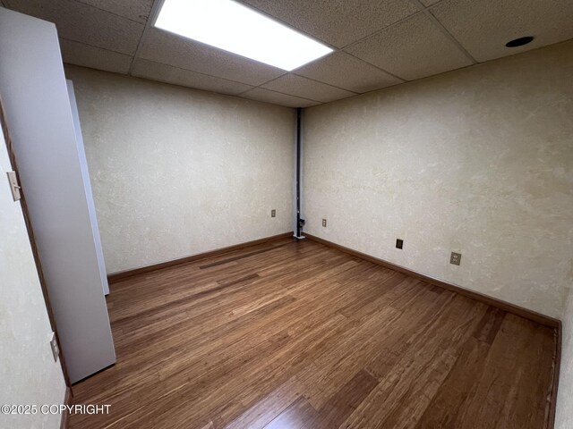 7700 Dover Ave, Anchorage, AK 99504 - spare room featuring wood finished floors, a paneled ceiling, and baseboards