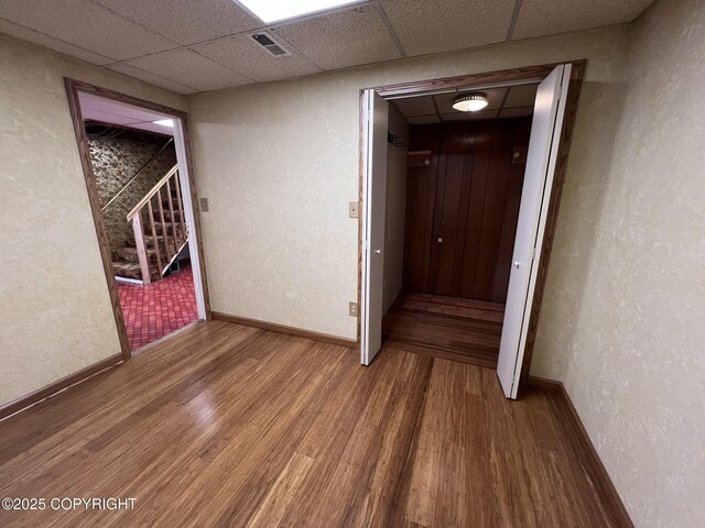 7700 Dover Ave, Anchorage, AK 99504 - hall with wood finished floors, baseboards, and a paneled ceiling