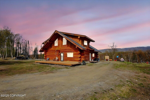 view of side of property featuring log exterior and a deck