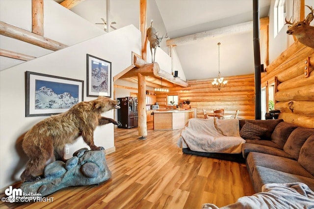 living room featuring high vaulted ceiling, log walls, a chandelier, light wood-type flooring, and beam ceiling