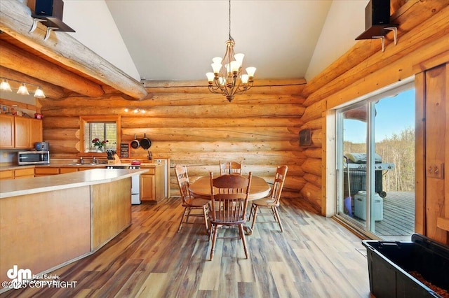 dining room featuring light wood finished floors, high vaulted ceiling, and a chandelier