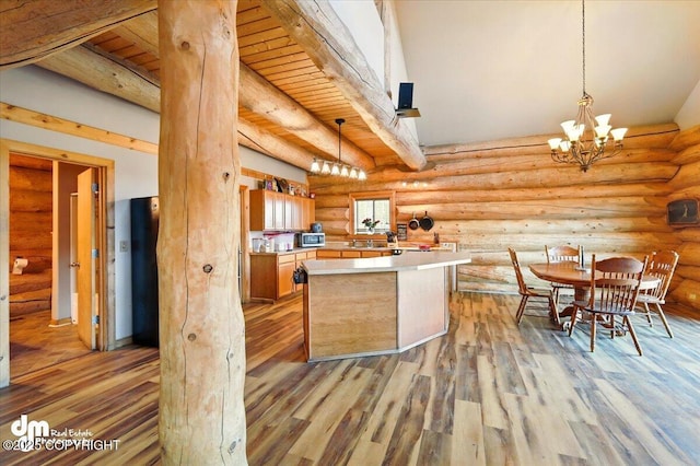 kitchen featuring a chandelier, light wood finished floors, light countertops, pendant lighting, and log walls
