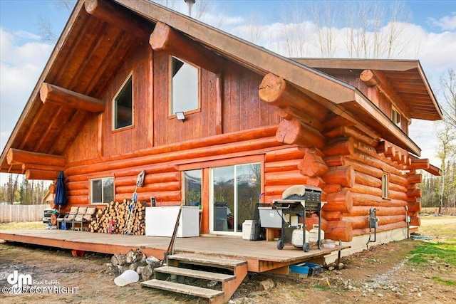rear view of house featuring log exterior and a wooden deck