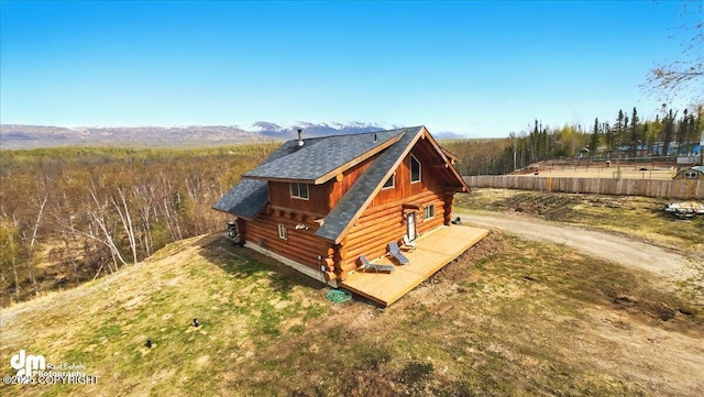 view of front facade featuring log exterior and roof with shingles