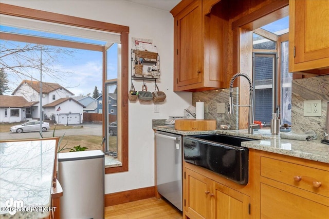 10613 Washington Cir, Anchorage, AK 99515 - kitchen with stainless steel dishwasher, baseboards, light wood finished floors, a sink, and tasteful backsplash