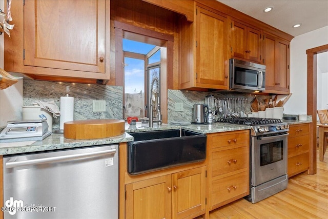 10613 Washington Cir, Anchorage, AK 99515 - kitchen featuring stainless steel appliances, a sink, light wood-style flooring, backsplash, and recessed lighting