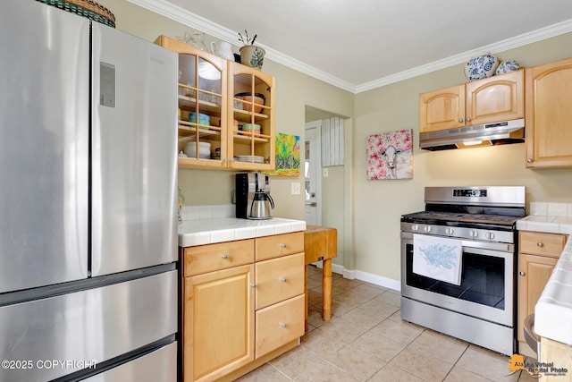 1008 Cordova St, Anchorage, AK 99501 - kitchen featuring stainless steel appliances, under cabinet range hood, light brown cabinets, tile countertops, and ornamental molding