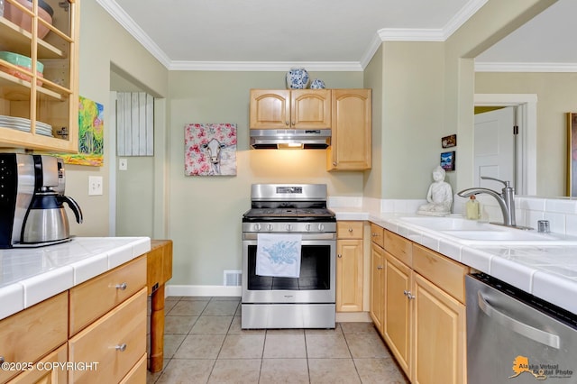 1008 Cordova St, Anchorage, AK 99501 - kitchen featuring stainless steel appliances, under cabinet range hood, a sink, light brown cabinets, and ornamental molding