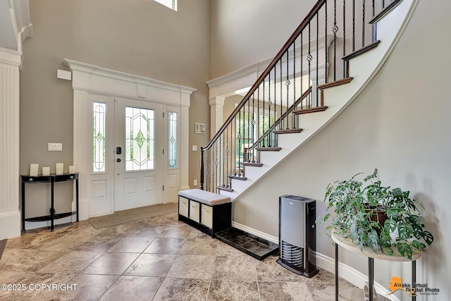 10588 E Nighthawk Cir, Palmer, AK 99645 - foyer with a towering ceiling, baseboards, stairway, stone tile floors, and decorative columns