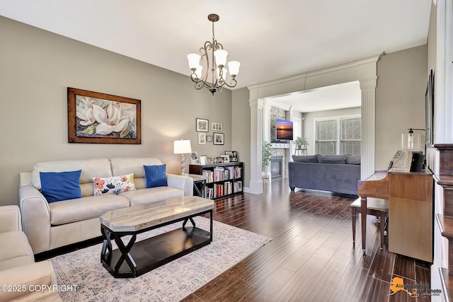 10588 E Nighthawk Cir, Palmer, AK 99645 - living room with a large fireplace, dark wood-style flooring, a chandelier, and ornate columns