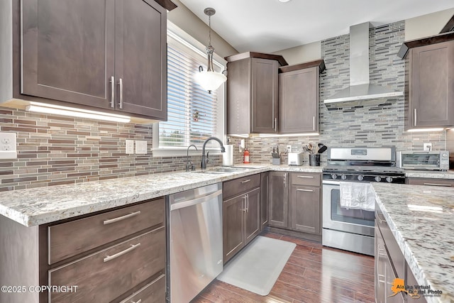 10588 E Nighthawk Cir, Palmer, AK 99645 - kitchen with appliances with stainless steel finishes, wall chimney range hood, a sink, dark wood-style flooring, and decorative backsplash