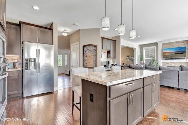 10588 E Nighthawk Cir, Palmer, AK 99645 - kitchen with stainless steel fridge, light wood-style flooring, open floor plan, pendant lighting, and recessed lighting