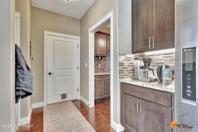 10588 E Nighthawk Cir, Palmer, AK 99645 - bar area featuring backsplash, dark wood-type flooring, stainless steel refrigerator with ice dispenser, and baseboards