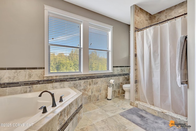 10588 E Nighthawk Cir, Palmer, AK 99645 - bathroom featuring a garden tub, toilet, a tile shower, a wainscoted wall, and tile walls