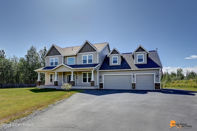 10588 E Nighthawk Cir, Palmer, AK 99645 - view of front facade with a porch, driveway, a garage, stone siding, and roof with shingles
