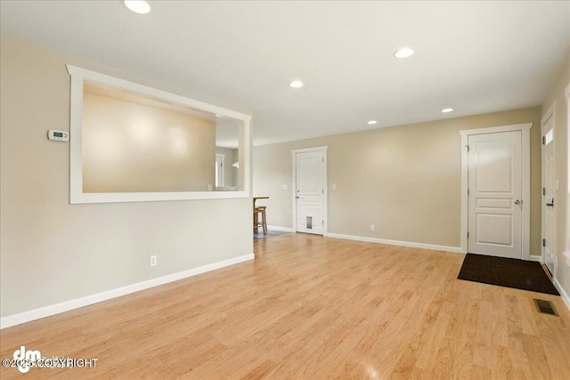 spare room featuring wood finished floors, baseboards, and recessed lighting