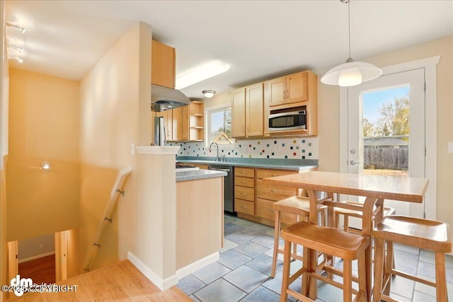 kitchen featuring light brown cabinetry, stainless steel appliances, decorative backsplash, open shelves, and pendant lighting