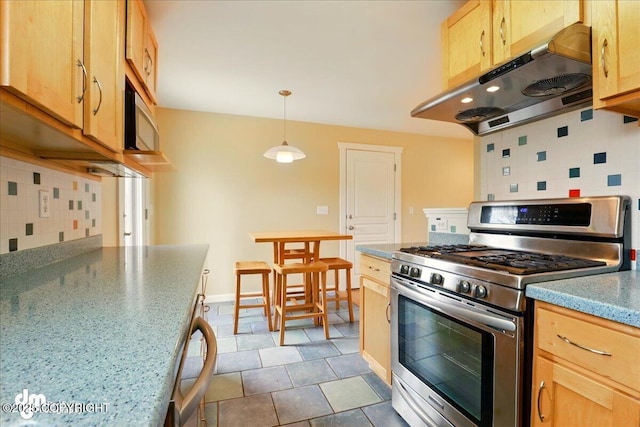 kitchen with stainless steel appliances, under cabinet range hood, backsplash, and light brown cabinets
