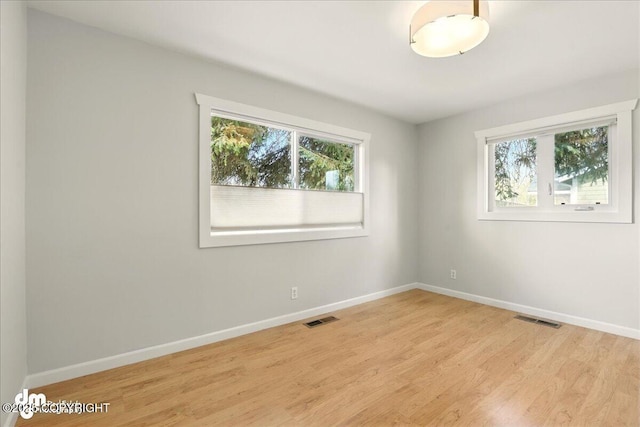 spare room with light wood-type flooring and baseboards