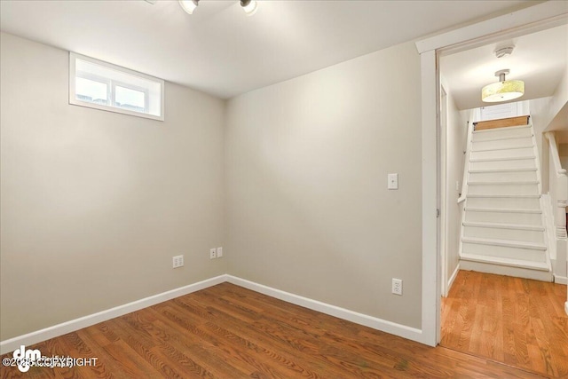 below grade area with wood finished floors, stairs, and baseboards