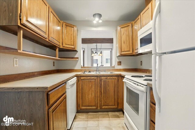 kitchen featuring white appliances, a sink, open shelves, light countertops, and a chandelier