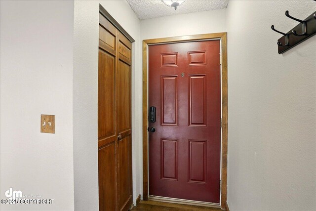 doorway to outside with a textured ceiling