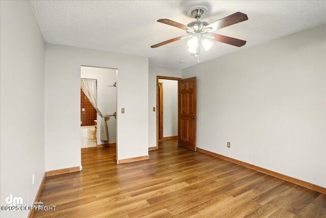 unfurnished room with light wood finished floors, baseboards, a ceiling fan, and a textured ceiling