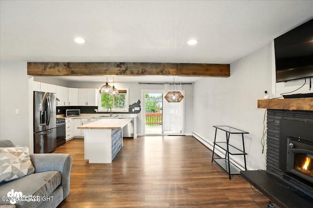 1831 S Salem Dr, Anchorage, AK 99508 - kitchen featuring appliances with stainless steel finishes, beamed ceiling, open floor plan, a sink, and light countertops
