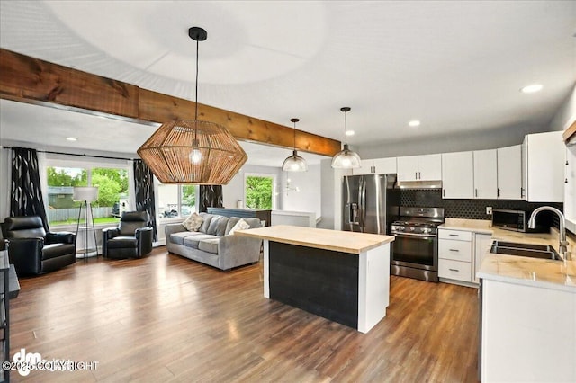 1831 S Salem Dr, Anchorage, AK 99508 - kitchen featuring appliances with stainless steel finishes, a sink, under cabinet range hood, a center island, and dark wood-type flooring