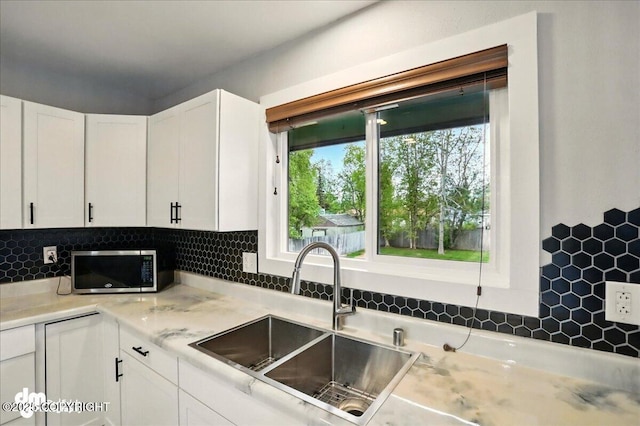 1831 S Salem Dr, Anchorage, AK 99508 - kitchen with a sink, stainless steel microwave, white cabinetry, and backsplash