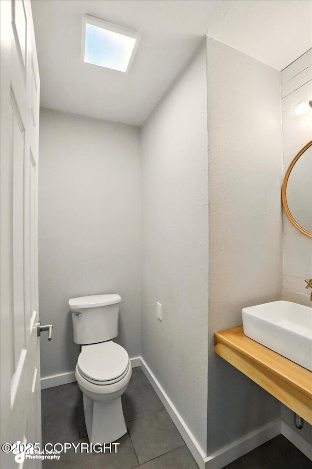 1831 S Salem Dr, Anchorage, AK 99508 - bathroom featuring toilet, baseboards, tile patterned flooring, and a sink