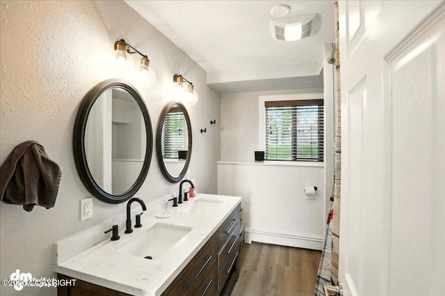 1831 S Salem Dr, Anchorage, AK 99508 - bathroom with baseboard heating, double vanity, and wood finished floors