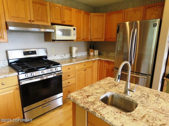 2340 E End Rd, Homer, AK 99603 - kitchen featuring stainless steel appliances, ventilation hood, light stone counters, and light wood-style flooring