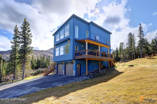 8236 Byron Dr, Anchorage, AK 99516 - rear view of house featuring stairway, an attached garage, a yard, driveway, and a deck with mountain view