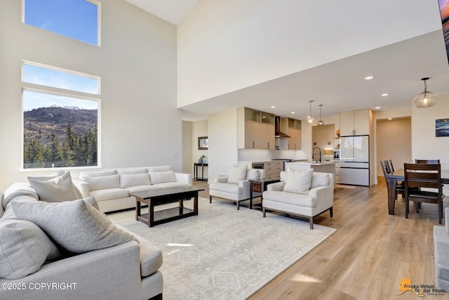 8236 Byron Dr, Anchorage, AK 99516 - living room featuring light wood-type flooring, a high ceiling, a mountain view, and recessed lighting