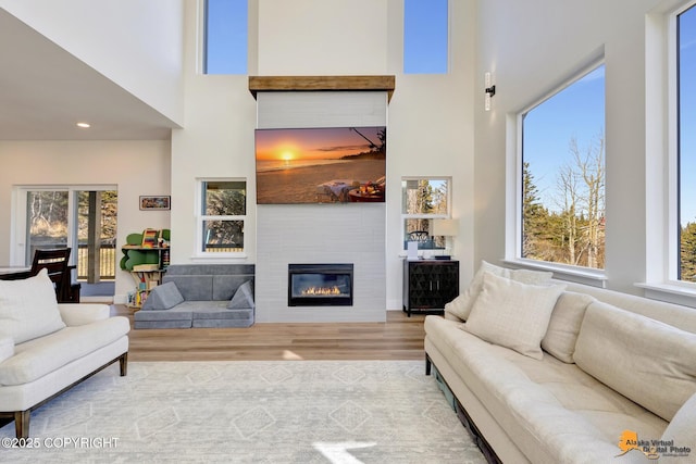 8236 Byron Dr, Anchorage, AK 99516 - living area featuring a high ceiling, wood finished floors, a large fireplace, plenty of natural light, and recessed lighting
