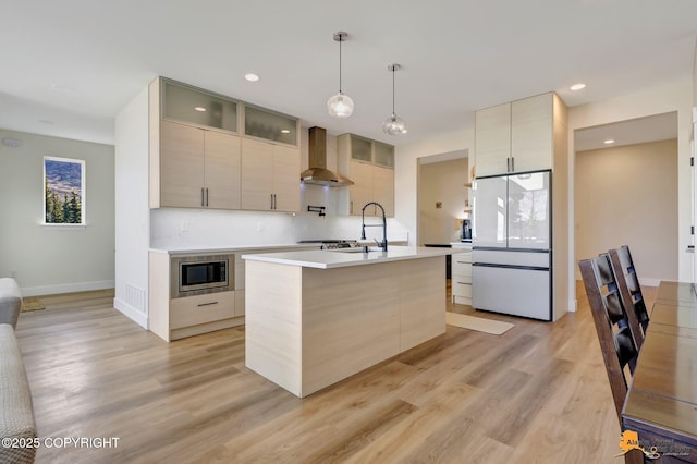 8236 Byron Dr, Anchorage, AK 99516 - kitchen with wall chimney range hood, stainless steel microwave, freestanding refrigerator, light countertops, and modern cabinets