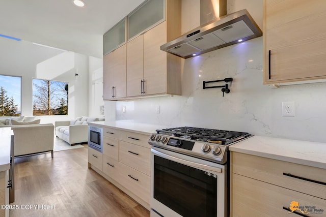 8236 Byron Dr, Anchorage, AK 99516 - kitchen featuring stainless steel appliances, wall chimney range hood, decorative backsplash, open floor plan, and glass insert cabinets