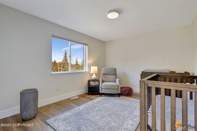 8236 Byron Dr, Anchorage, AK 99516 - bedroom featuring baseboards, wood finished floors, and a nursery area