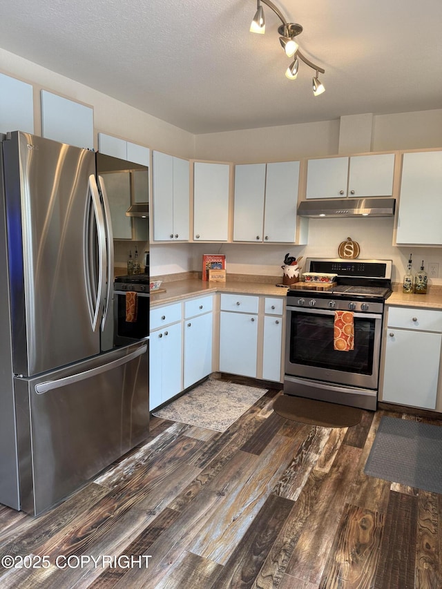 981 E Susitna Dr, Wasilla, AK 99654 - kitchen featuring appliances with stainless steel finishes, under cabinet range hood, dark wood-type flooring, light countertops, and white cabinets