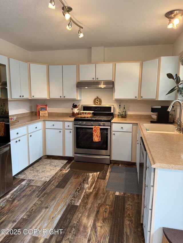 981 E Susitna Dr, Wasilla, AK 99654 - kitchen featuring gas range, under cabinet range hood, a sink, dark wood-style floors, and light countertops