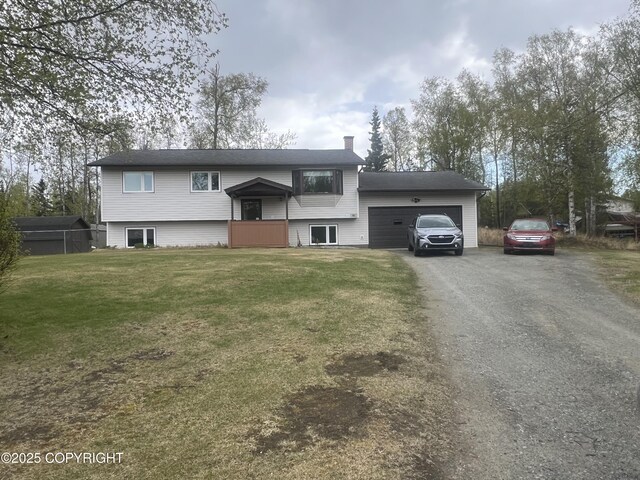 981 E Susitna Dr, Wasilla, AK 99654 - bi-level home with an attached garage, a chimney, driveway, and a front lawn