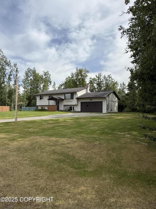 981 E Susitna Dr, Wasilla, AK 99654 - view of front of home featuring a garage, driveway, a chimney, and a front yard