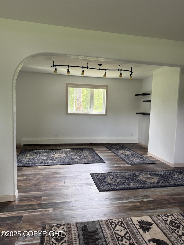 981 E Susitna Dr, Wasilla, AK 99654 - empty room featuring arched walkways, wood finished floors, and track lighting