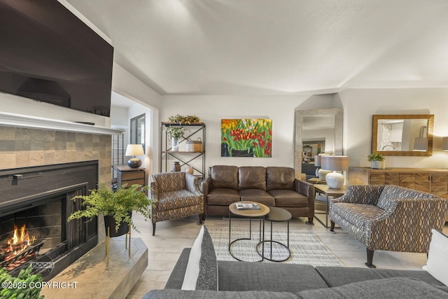 living room with a tiled fireplace and wood finished floors