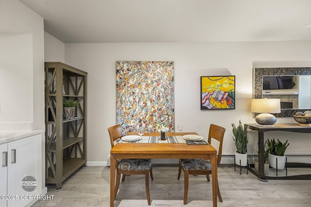 dining room featuring light wood-type flooring and baseboards