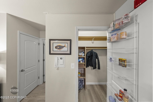 corridor featuring wood finished floors and baseboards